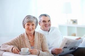 smiling-couple-drinking-coffee-and-reading-the-newspaper_1098-1168